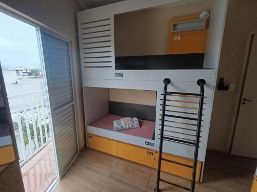 a bunk bed in a room with a large window at Hostel Aeroporto in Guarulhos