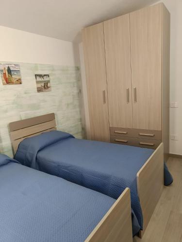 a bedroom with two beds and a cabinet at La Terrazza di Simo in Trinità dʼAgultu