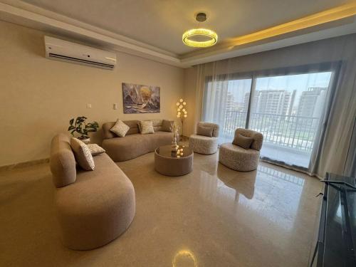 a living room with couches and chairs and a large window at zayed in Sheikh Zayed