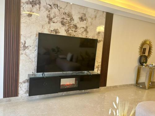 a living room with a tv and a fireplace at zayed in Sheikh Zayed