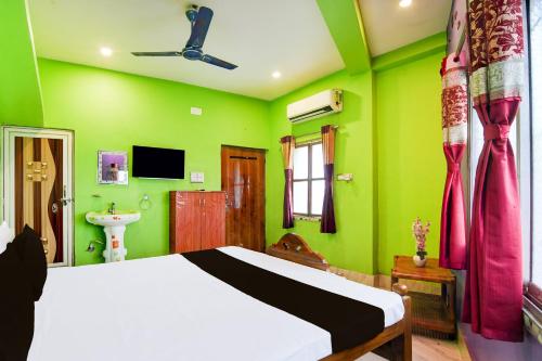 um quarto com paredes verdes, uma cama e um lavatório em Hotel O A R Lodge em Durgāpur