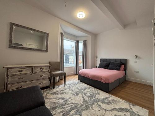 a bedroom with a bed and a dresser at Bedford Guesthouse in Liverpool