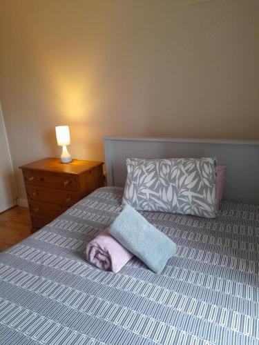 - un lit avec un oreiller et 2 serviettes dans l'établissement Kathleen Apartment, à Galway