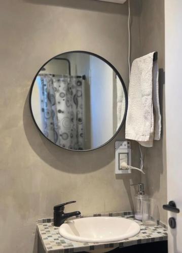 a bathroom with a mirror and a sink at Lalau Casa de Playa in Chapadmalal