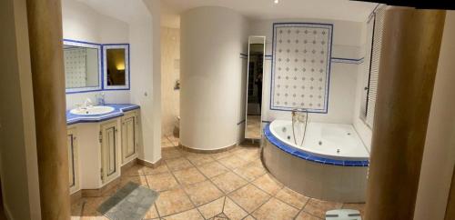 La salle de bains est pourvue d'une baignoire, de 2 lavabos et d'une baignoire. dans l'établissement Domaine des Tuilières avec piscine, à Vallauris
