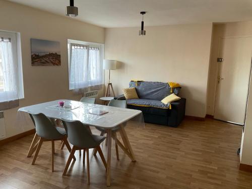 a living room with a table and a couch at Grand T2 Côte de granit rose plages et commerces à proximité in Trégastel