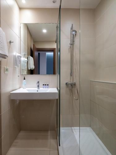 ein Badezimmer mit Waschbecken und Dusche in der Unterkunft Athinaikon Hotel in Iraklio
