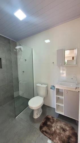 a bathroom with a toilet and a shower and a sink at Casa Mar2 in Balneário Gaivotas