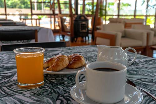 a cup of coffee and a plate of croissants and a cup of coffee at Hotel ACA Eldorado in Eldorado