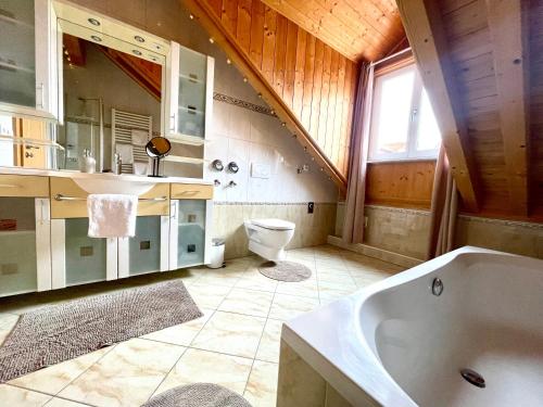 a bathroom with a tub and a sink and a toilet at Loftwohnung Sankt Wolfgang in Sankt Wolfgang