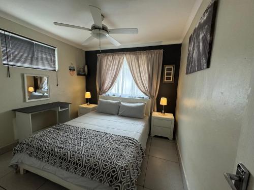 una camera da letto con un letto e un ventilatore a soffitto di Secure cottage with Wifi and PLEX OR Tambo Airport a Germiston