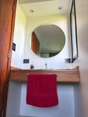 a bathroom with a red towel and a mirror at Don Miguel in Balcarce