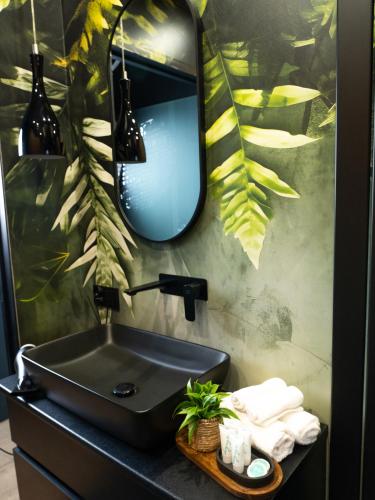 a bathroom with a black sink and a mirror at Apartamenty 3 Maja in Płock