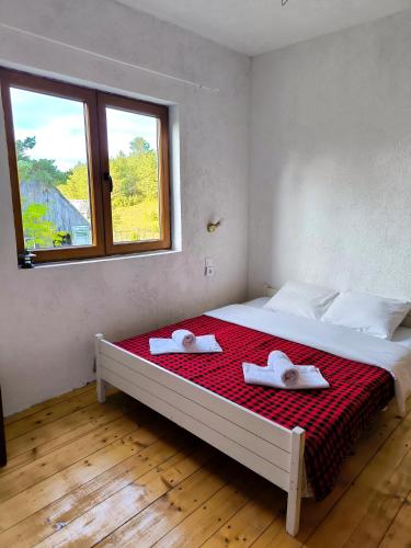 a bedroom with a large bed with two towels on it at Vukov Konak - Wolf's lodge in Žabljak