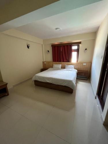 a large bedroom with a bed and a window at Hotel danor in Gangtok