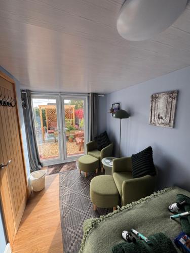 a living room with a couch and chairs and a window at Julara in Deganwy