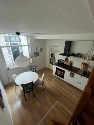 a living room with a table and a kitchen at Cute cottage house in the city centre with terrace in The Hague