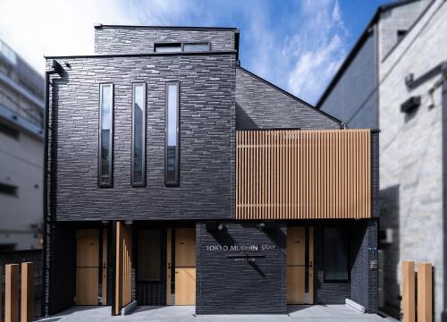 a black brick house with a wooden facade at Tokyo Modern Stay Shinjuku in Tokyo