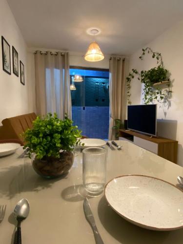 a table with a plate and a vase on it at Apartamento completo proximo as Praias do Litoral Sul in João Pessoa