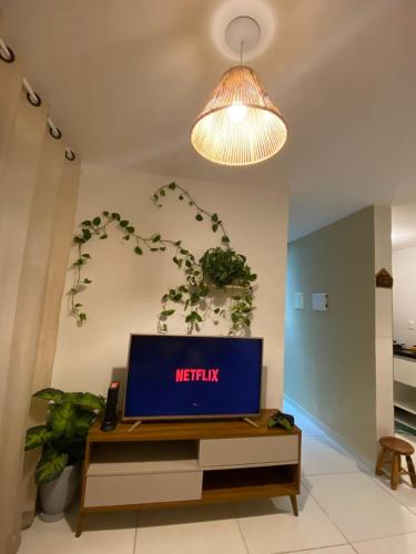 sala de estar con mesa y TV en Apartamento completo proximo as Praias do Litoral Sul, en João Pessoa