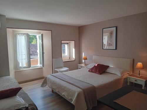 a hotel room with a bed and two windows at Hôtel La Gravenne in Thueyts