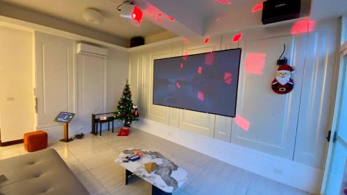Una sala de estar con un árbol de Navidad y un televisor de pantalla plana. en Mushin Club 沐心智苑會館, en Wujie