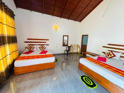 a bedroom with two beds and a table and chairs at Sigiri White Queen's Lodge in Sigiriya