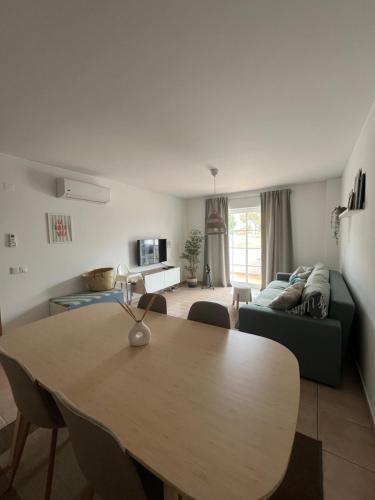 a living room with a table and a couch at Cabanas De Miramar in Tavira