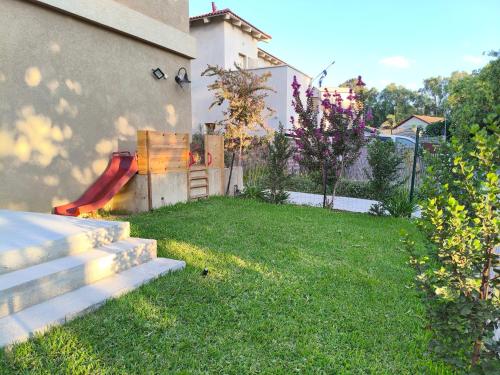 a backyard with a red slide in the grass at אורן בשדה in Sede Ilan
