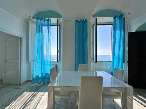 a dining room with blue curtains and a table and chairs at Casa al Prino in Imperia