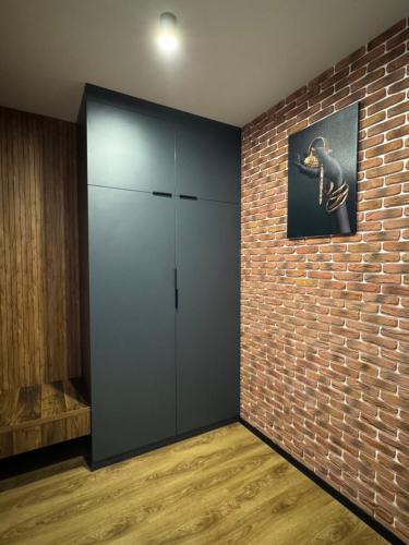 a room with a brick wall and a large cabinet at Дизайнерські апартаменти в ЖК DreamTown in Luts'k