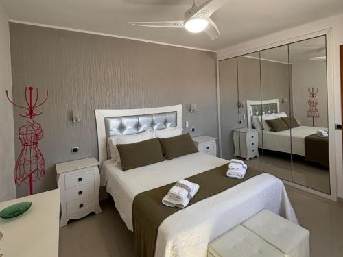 ein Schlafzimmer mit zwei Betten und einem Spiegel in der Unterkunft El rincón de Cornelia en Tejeda in Tejeda