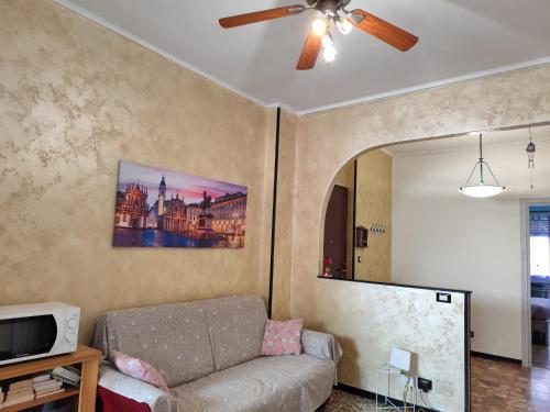 a living room with a couch and a ceiling fan at La casa di Anna in Collegno
