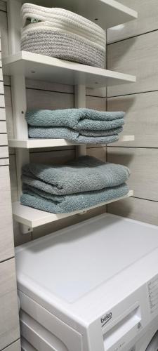 a closet with a stack of towels and a printer at Jaukūs, erdvūs, šilti apartamentai in Klaipėda