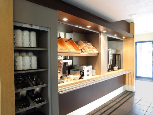 a shelf in a kitchen with food items at B&B HOTEL Montpellier 2 in Saint-Jean-de-Védas