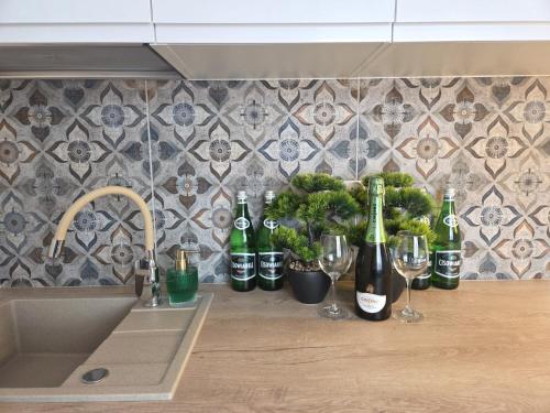 a kitchen counter with wine bottles and wine glasses at Leśny Zakątek I Małe Bieszczady w Rzeszowie I grill sauna Starowiejska 6 Rzeszów in Rzeszów
