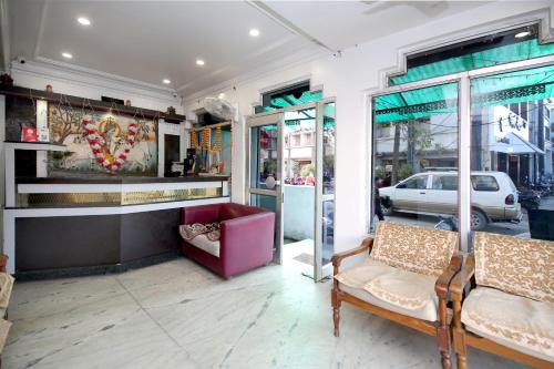 eine Ladenfront mit zwei Stühlen und einem rosa Sofa in der Unterkunft Hotel O Dwarika Inn in Jabalpur