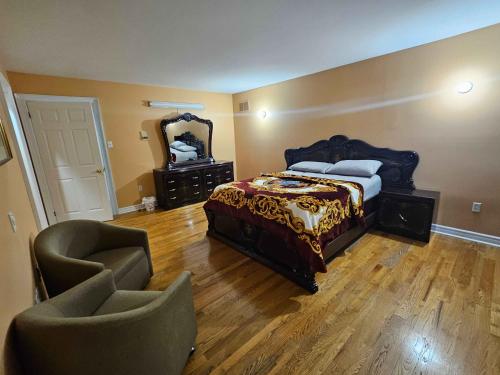 a bedroom with a bed and a mirror and two chairs at White House Canada in Brampton
