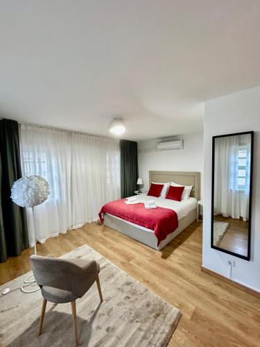 a bedroom with a bed and a chair and a mirror at Aquae Flaviae Urban Stay - Charm in Chaves