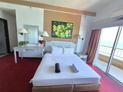 a bedroom with a large white bed and a large window at Rainbow paradise by Farhad in Tanjung Bungah