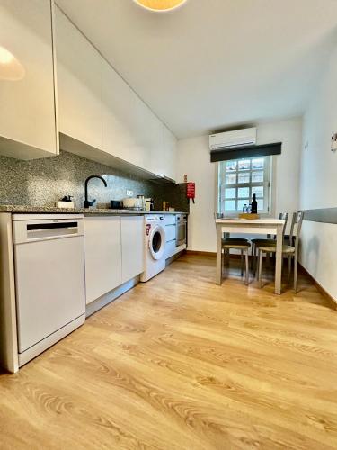a kitchen with a table and a sink and a dishwasher at Aquae Flaviae Urban Stay - Charm in Chaves