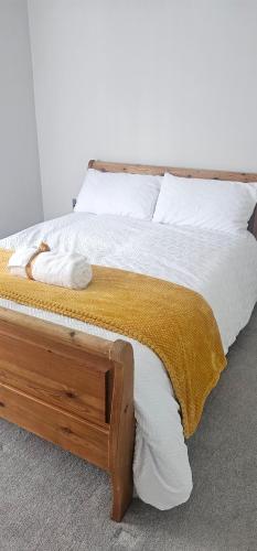 1 cama con marco de madera y sábanas y almohadas blancas en Lala Stays Htpool, en Hartlepool
