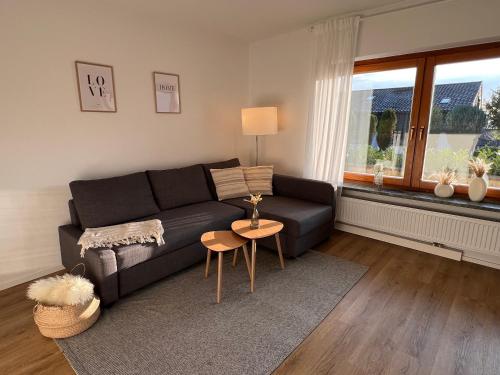 a living room with a black couch and a table at Wohnglück Seifferer in Ravensburg