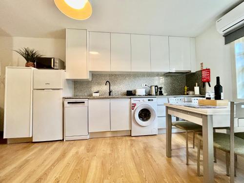 a kitchen with white cabinets and a washer and dryer at Aquae Flaviae Urban Stay - Charm in Chaves