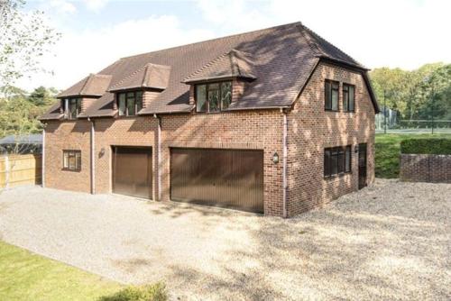 a large brick house with two garage doors at Salvi's Hideout in Sarisbury Green