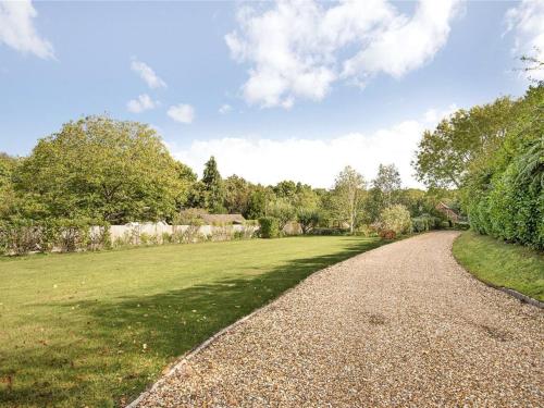 a gravel road leading through a grassy field at Salvi's Hideout in Sarisbury Green