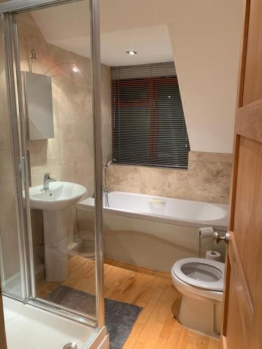 a bathroom with a tub and a toilet and a sink at Salvi's Hideout in Sarisbury Green