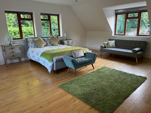 a bedroom with a bed and a couch and a green rug at Salvi's Hideout in Sarisbury Green