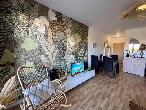 a living room with a wall mural of flowers at T3 Lumineux avec super Terrasse in Saint-Gilles-Croix-de-Vie