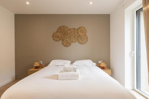 a bedroom with a large white bed with two towels at Zest Boheme Villeurbanne in Saint-Priest
